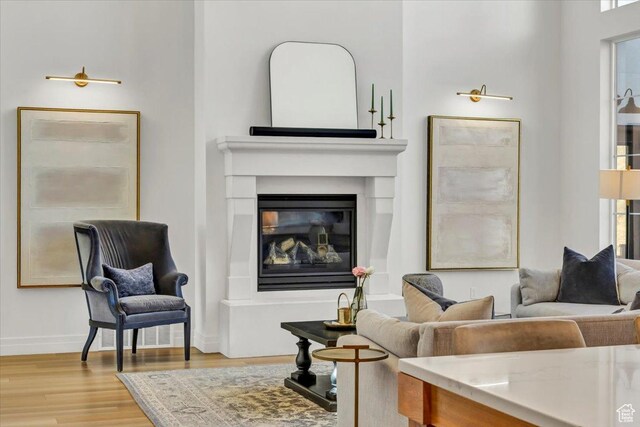 4875 N Vialetto Way, Lehi, UT 84043 - living area featuring a glass covered fireplace, wood finished floors, and baseboards