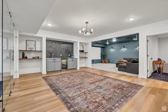4875 N Vialetto Way, Lehi, UT 84043 - living room featuring wine cooler, light wood-style floors, an inviting chandelier, baseboards, and a dry bar