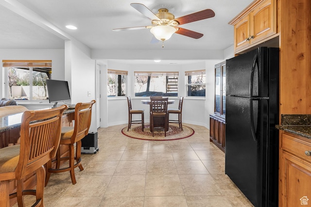 3265 N 1050 W, Pleasant View, UT 84414 - kitchen with brown cabinetry, baseboards, freestanding refrigerator, light tile patterned flooring, and a ceiling fan