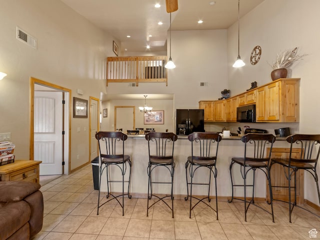 2 Desert Wind Dr Unit 2, Moab, UT 84532 - kitchen featuring a breakfast bar area, visible vents, a peninsula, light tile patterned flooring, and black appliances