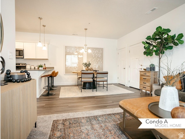 13687 S Hanley Ln Unit Dd301, Riverton, UT 84096 - living area featuring visible vents, baseboards, a notable chandelier, and wood finished floors