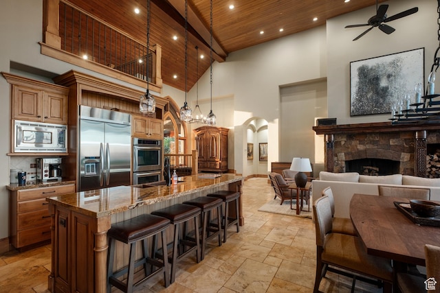 8376 E Aspen Rdg Unit 44, Heber City, UT 84032 - kitchen with built in appliances, stone tile floors, high vaulted ceiling, arched walkways, and ceiling fan