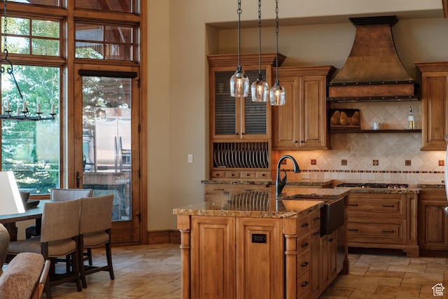 8376 E Aspen Rdg Unit 44, Heber City, UT 84032 - kitchen with custom exhaust hood, stainless steel gas cooktop, light stone countertops, backsplash, and hanging light fixtures