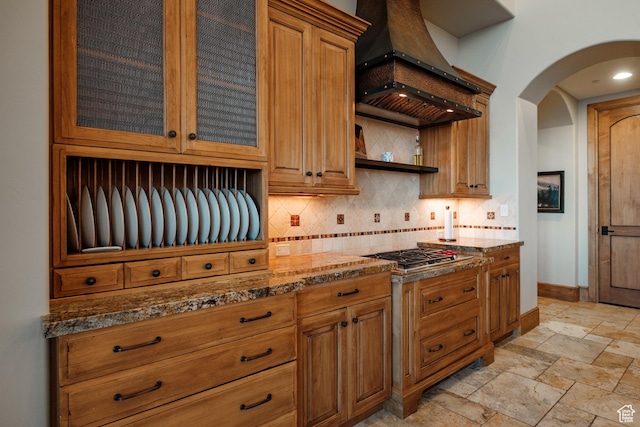8376 E Aspen Rdg Unit 44, Heber City, UT 84032 - kitchen featuring stainless steel gas cooktop, custom exhaust hood, backsplash, arched walkways, and dark stone countertops