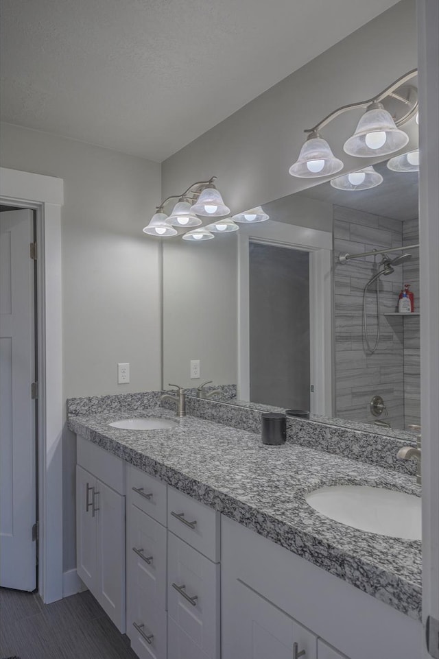 1997 E Abbey Way S, Eagle Mountain, UT 84005 - full bathroom with double vanity, wood finished floors, tiled shower, and a sink