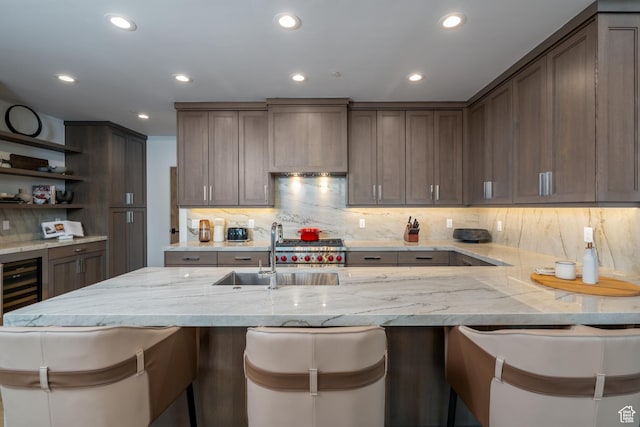 5790 Cobalt Cir, Park City, UT 84098 - kitchen featuring a breakfast bar, open shelves, light stone countertops, and a sink