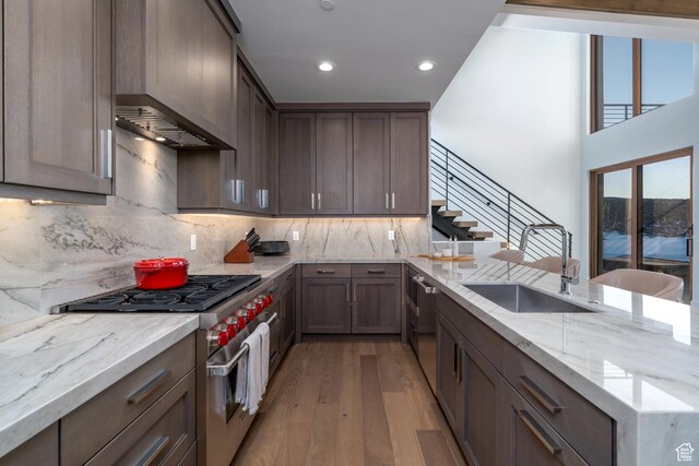 5790 Cobalt Cir, Park City, UT 84098 - kitchen with light stone countertops, light wood finished floors, a peninsula, a sink, and appliances with stainless steel finishes