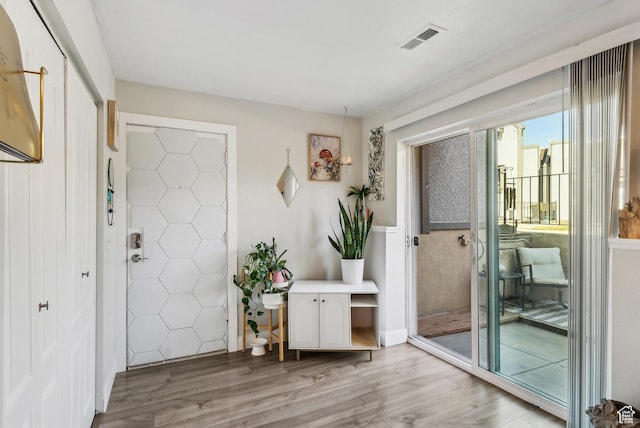 foyer entrance featuring light wood finished floors and visible vents