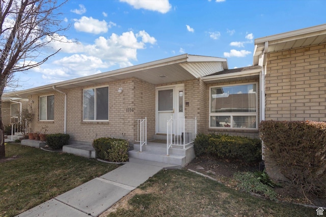 view of front of home with a front lawn and brick siding