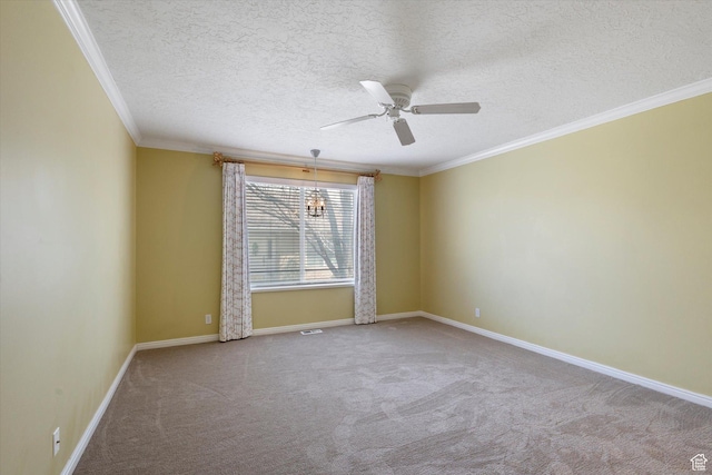 empty room featuring ceiling fan, baseboards, ornamental molding, carpet floors, and a textured ceiling