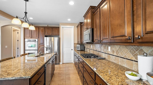 69 W Grove Creek Cir N, Farmington, UT 84025 - kitchen with stainless steel appliances, a sink, light stone countertops, a kitchen island with sink, and recessed lighting