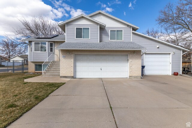 2350 N 720 W, Layton, UT 84041 - split level home featuring driveway, roof mounted solar panels, fence, a front yard, and brick siding