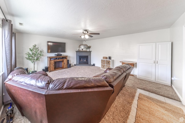 2350 N 720 W, Layton, UT 84041 - living area with visible vents, a glass covered fireplace, a textured ceiling, light colored carpet, and ceiling fan