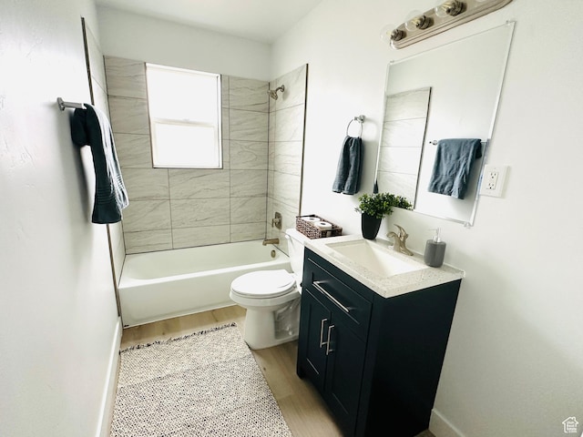full bath with vanity, wood finished floors, baseboards, bathtub / shower combination, and toilet
