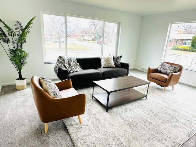 living area featuring plenty of natural light, carpet, and baseboards