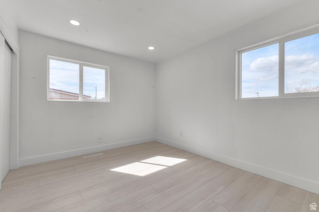 unfurnished room featuring visible vents, recessed lighting, light wood-type flooring, and baseboards