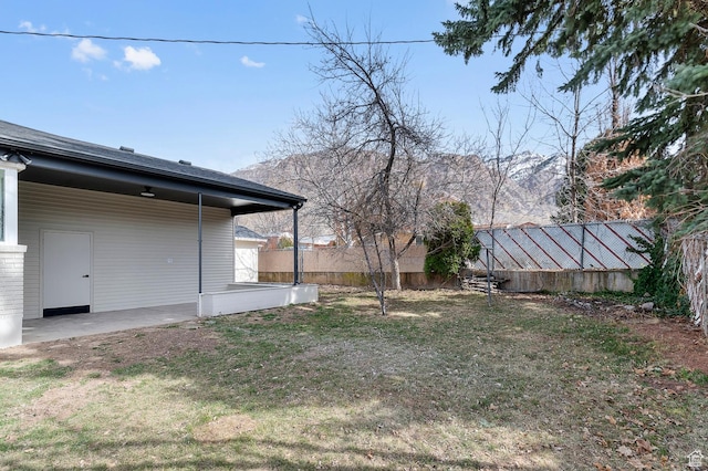 view of yard with a patio area, a mountain view, and fence