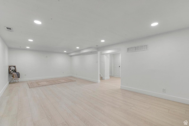 finished basement with recessed lighting, visible vents, light wood finished floors, and baseboards