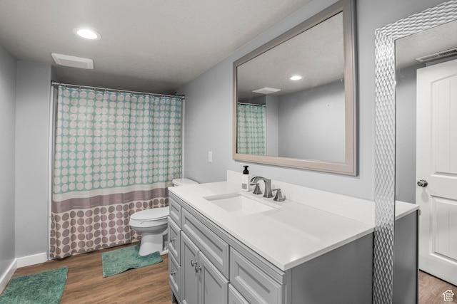 full bathroom featuring visible vents, toilet, recessed lighting, wood finished floors, and vanity