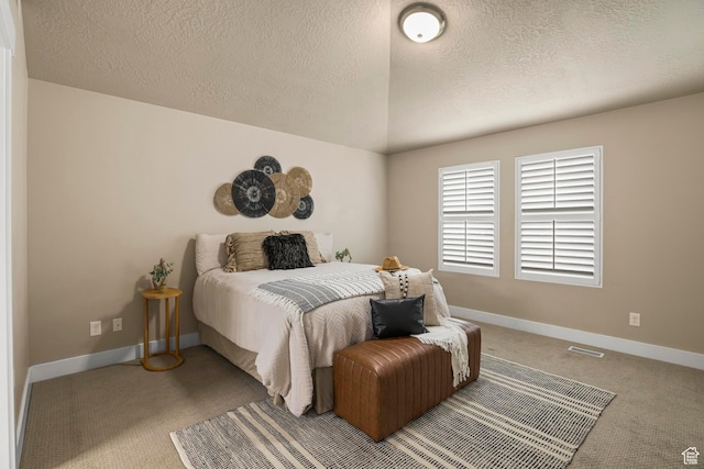 bedroom with visible vents, lofted ceiling, a textured ceiling, carpet, and baseboards