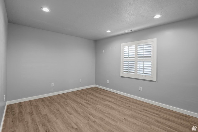 spare room with visible vents, recessed lighting, wood finished floors, and baseboards