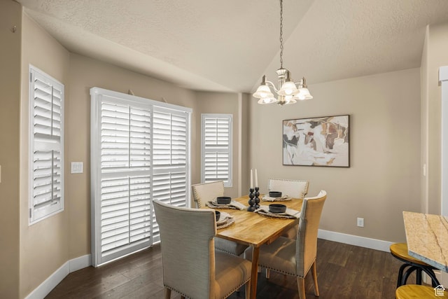 dining area with dark wood-type flooring, baseboards, a chandelier, vaulted ceiling, and a textured ceiling