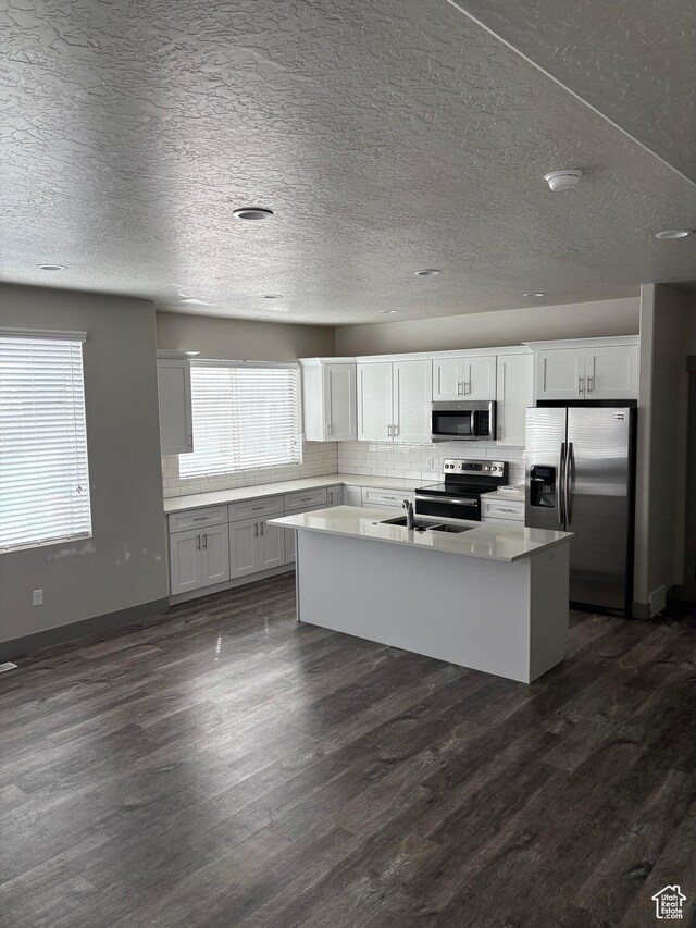 12734 S 1630 W, Riverton, UT 84065 - kitchen featuring stainless steel appliances, dark wood finished floors, an island with sink, and decorative backsplash
