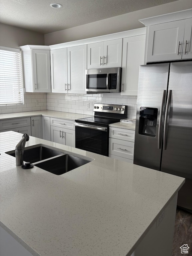 12734 S 1630 W, Riverton, UT 84065 - kitchen featuring light stone counters, a sink, backsplash, and stainless steel appliances