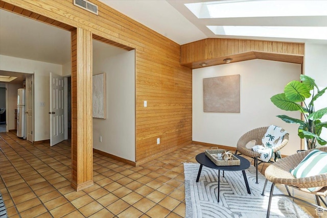 1231 E Brickyard Rd Unit 505, Millcreek, UT 84106 - living area with a skylight, lofted ceiling, wooden walls, and light tile patterned floors