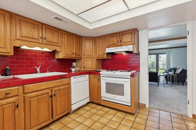 1231 E Brickyard Rd Unit 505, Millcreek, UT 84106 - kitchen featuring white appliances, under cabinet range hood, tile counters, light tile patterned floors, and backsplash