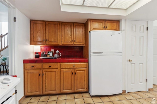 1231 E Brickyard Rd Unit 505, Millcreek, UT 84106 - kitchen with freestanding refrigerator, tile counters, and brown cabinets