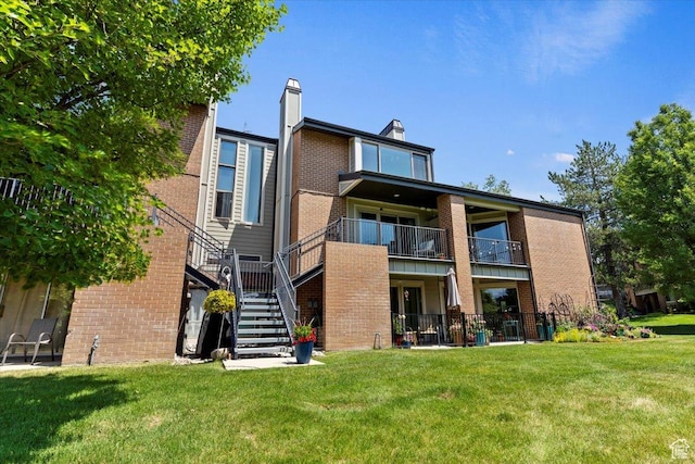 1231 E Brickyard Rd Unit 505, Millcreek, UT 84106 - rear view of property featuring brick siding, stairway, and a lawn