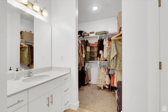 bathroom featuring vanity and a walk in closet