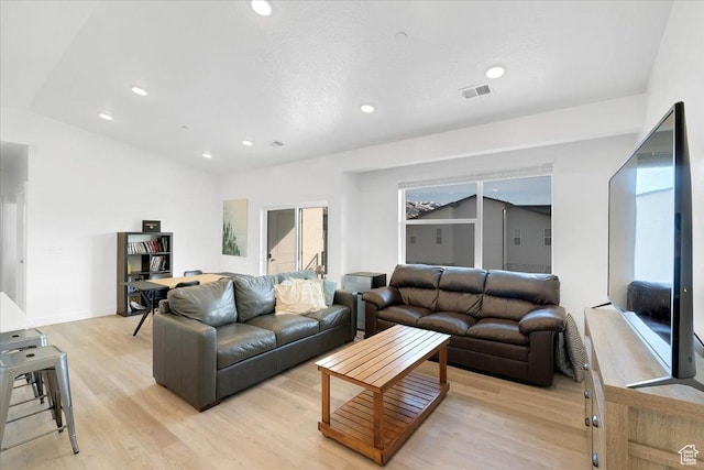 living room with recessed lighting, visible vents, and light wood finished floors