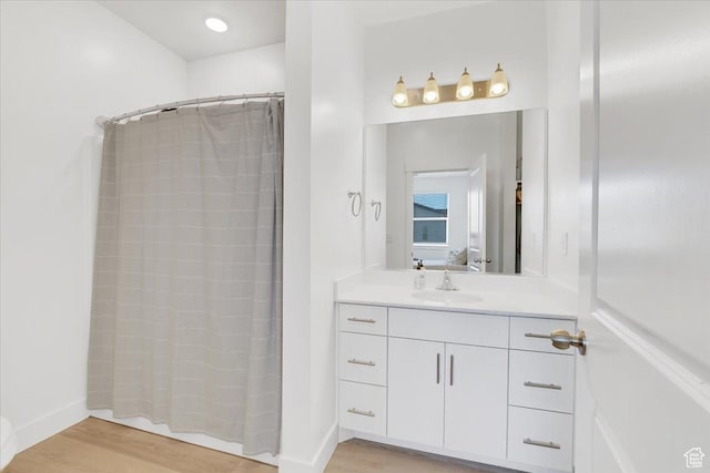 ensuite bathroom featuring vanity, a shower with curtain, wood finished floors, and connected bathroom