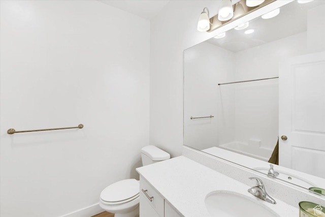 bathroom with vanity, toilet, and baseboards