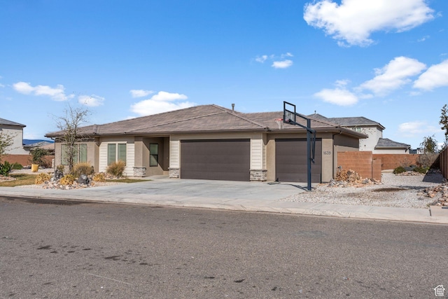 1639 E Yant Flant Dr, St George, UT 84790 - view of front of house featuring stone siding, concrete driveway, a garage, and fence