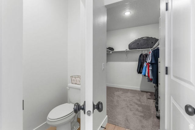 1639 E Yant Flant Dr, St George, UT 84790 - bathroom with baseboards, toilet, a spacious closet, and a textured ceiling