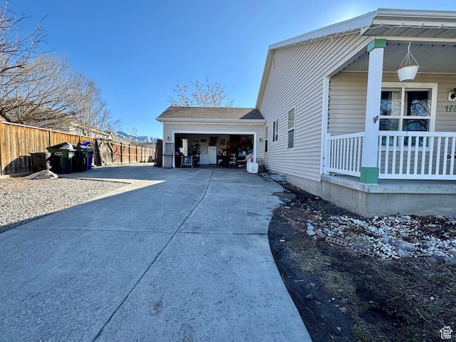 173 W Dimaggio Dr N, Tooele, UT 84074 - view of side of property featuring covered porch, driveway, an attached garage, and fence