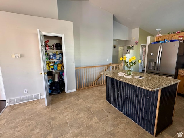 173 W Dimaggio Dr N, Tooele, UT 84074 - kitchen featuring light stone countertops, baseboards, visible vents, stainless steel fridge, and a center island
