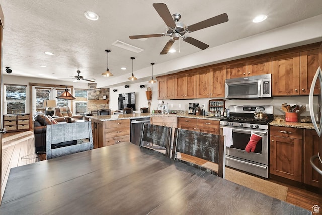 3518 N Moose Hollow Dr Unit 1402, Eden, UT 84310 - kitchen with a peninsula, brown cabinets, a ceiling fan, and stainless steel appliances