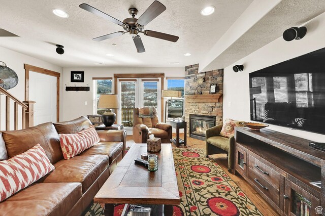 3518 N Moose Hollow Dr Unit 1402, Eden, UT 84310 - living room featuring a stone fireplace, recessed lighting, light wood-style flooring, a textured ceiling, and a ceiling fan
