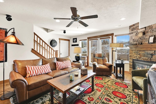 3518 N Moose Hollow Dr Unit 1402, Eden, UT 84310 - living room featuring a fireplace, a textured ceiling, a ceiling fan, stairway, and wood finished floors