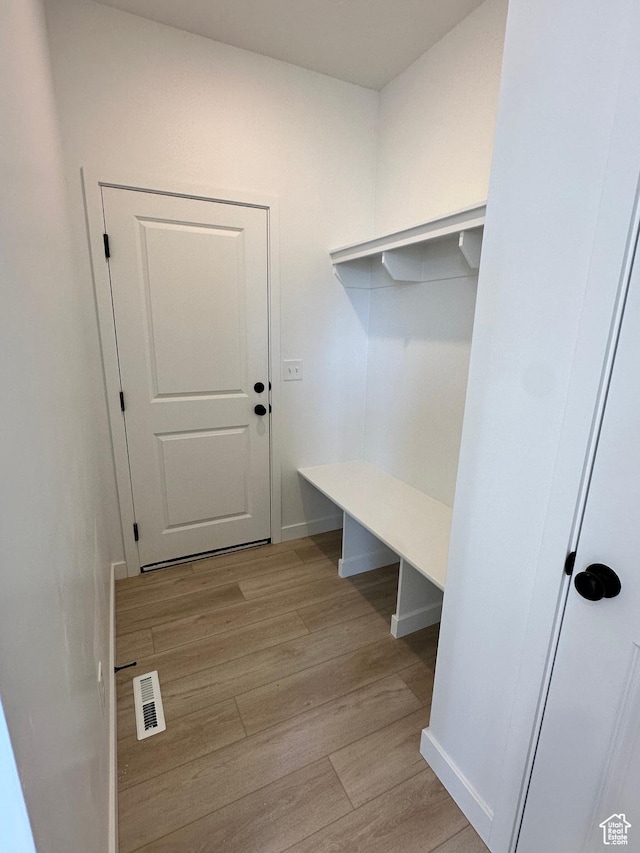mudroom featuring visible vents, light wood-style floors, and baseboards