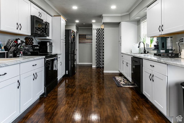 kitchen featuring dark wood-type flooring, black appliances, ornamental molding, a sink, and white cabinets