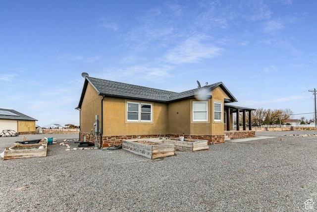 view of home's exterior with a garden and stucco siding