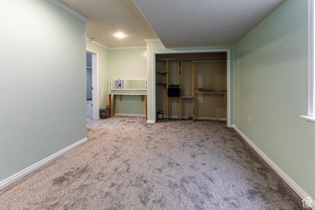 unfurnished bedroom featuring a closet, baseboards, carpet flooring, and crown molding