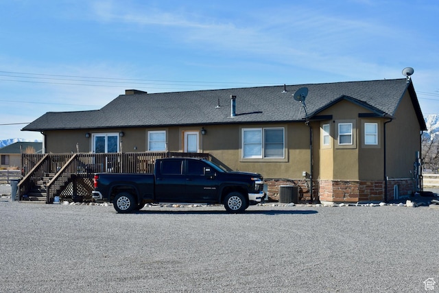 view of front of house with roof with shingles and stucco siding