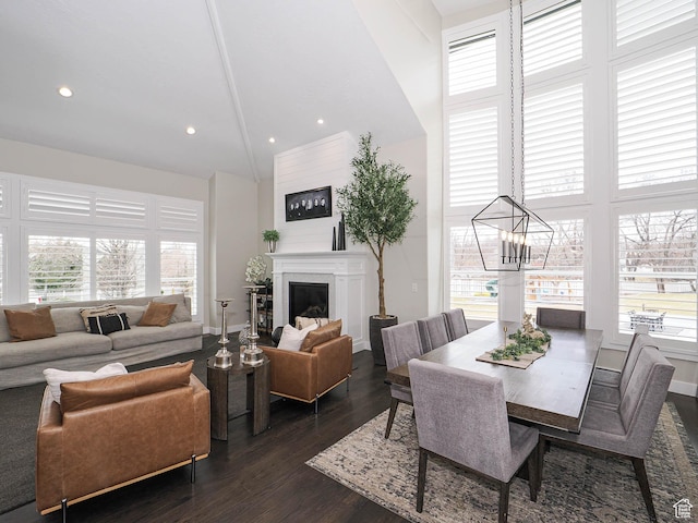 1146 W Jordan River Dr, South Jordan, UT 84095 - dining space featuring dark wood finished floors, recessed lighting, a towering ceiling, a glass covered fireplace, and a notable chandelier