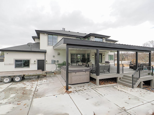 1146 W Jordan River Dr, South Jordan, UT 84095 - back of property featuring a wooden deck, a patio, stucco siding, and a hot tub